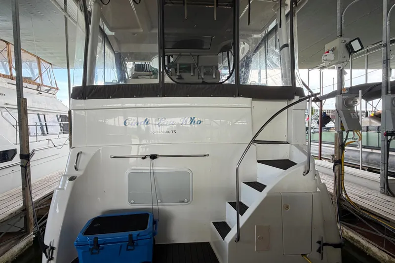 Slide: The Image of 1998 Silverton 352 Motor Yacht docked, featuring rear view with stairs and blue cooler. - 4