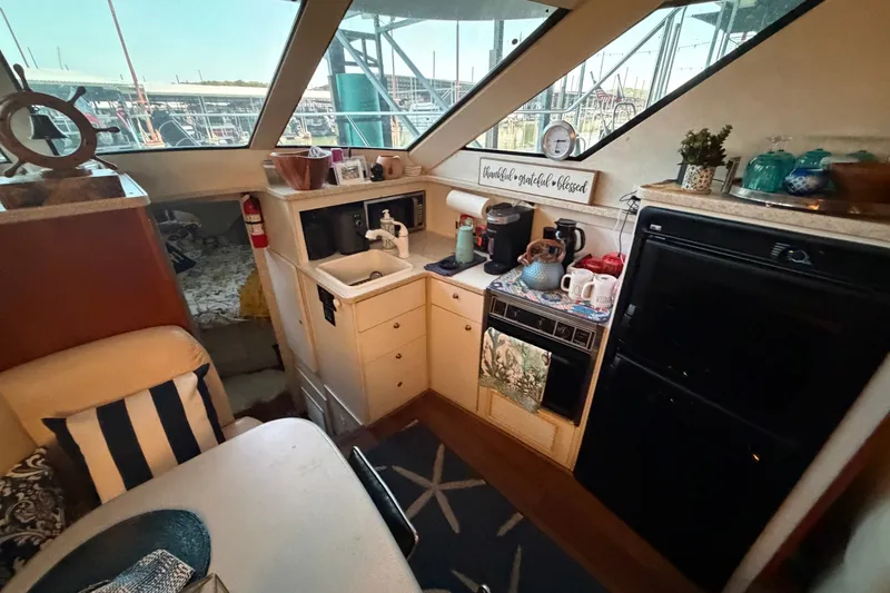 Slide: The Image of Interior of 1998 Silverton 352 Motor Yacht with kitchenette and dining area. - 13