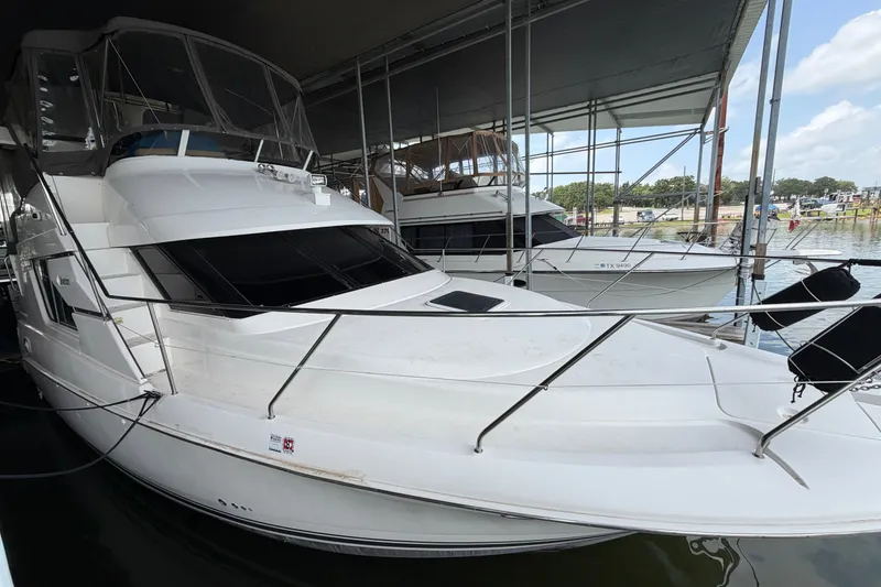 The Image of 1998 Silverton 352 Motor Yacht docked in a marina under a covered shelter. - 7