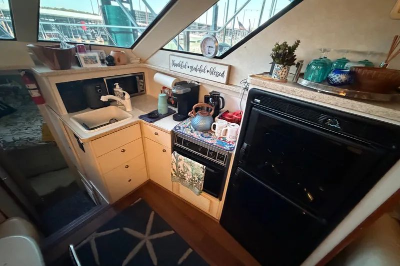 Slide: The Image of Cozy kitchen area in a 1998 Silverton 352 Motor Yacht with modern amenities. - 14