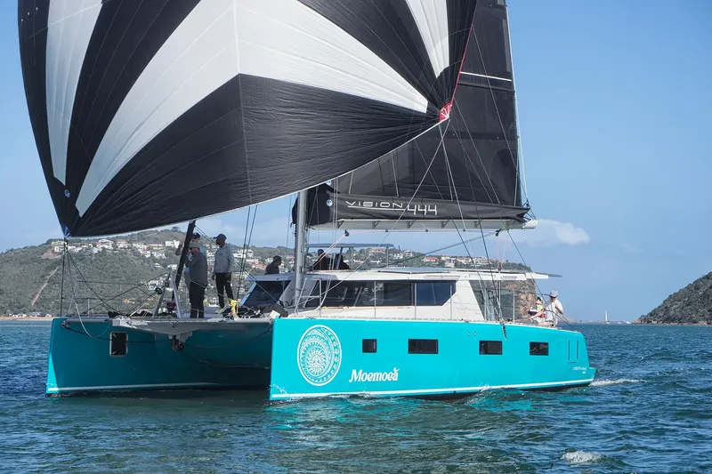 The Image of 2024 Vision 444ES catamaran sailing with black and white sails on a sunny day. - 0