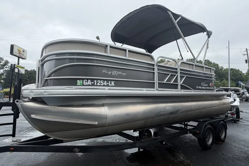 The Image of 2021 SUNTRACKER Party Barge 20 DLX pontoon boat on trailer, overcast day. - 1