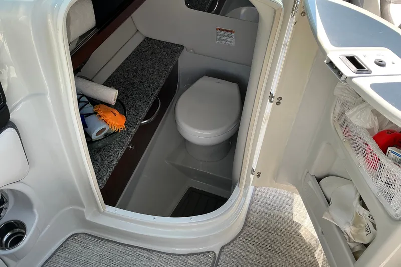 Slide: The Image of 2022 Crownline 290 SS boat bathroom with granite countertop and compact toilet. - 21