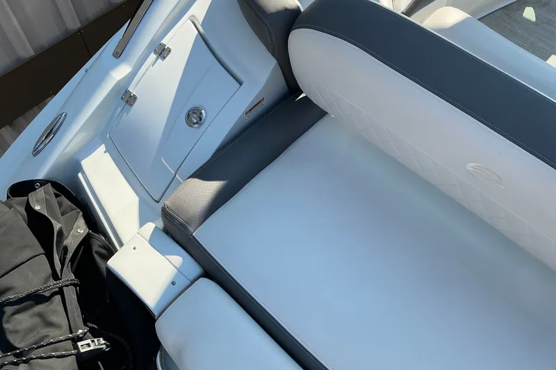 Slide: The Image of 2022 Crownline 290 SS boat interior with white seating and storage compartment. - 15