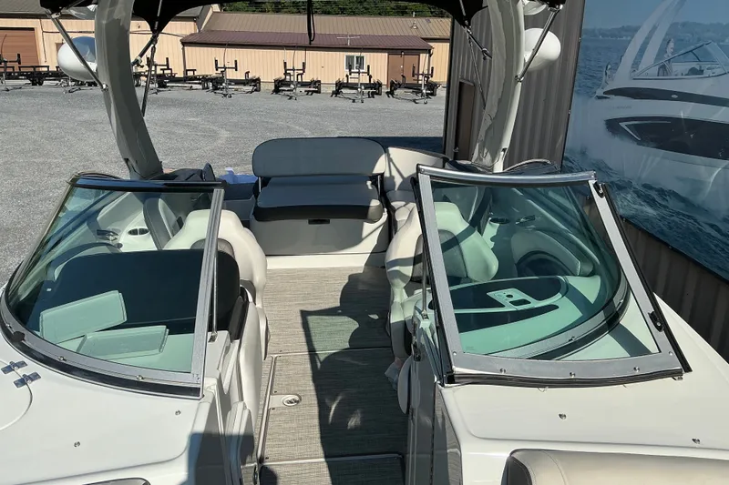 Slide: The Image of 2022 Crownline 290 SS boat interior with seating and windshield, displayed outdoors. - 25