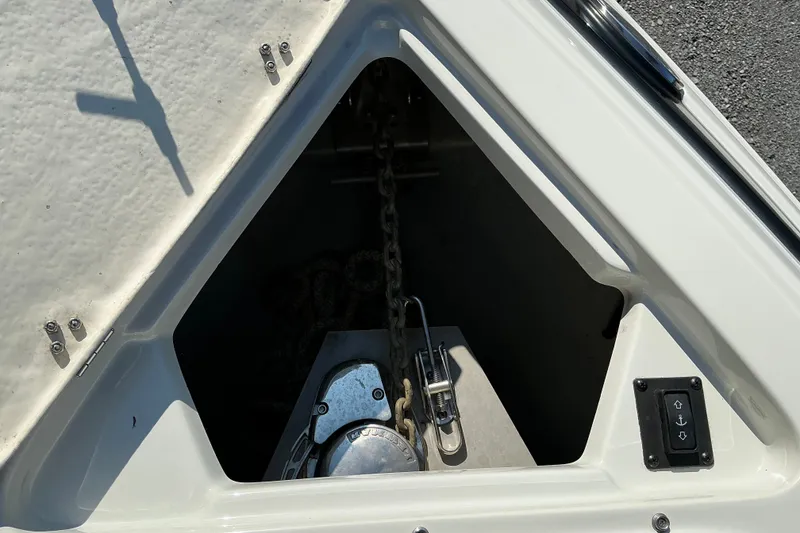 Slide: The Image of Anchor compartment of 2022 Crownline 290 SS boat with chain and control panel. - 24