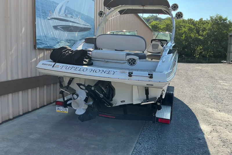 Slide: The Image of 2022 Crownline 290 SS boat named "Tupelo Honey" on trailer, rear view. - 10
