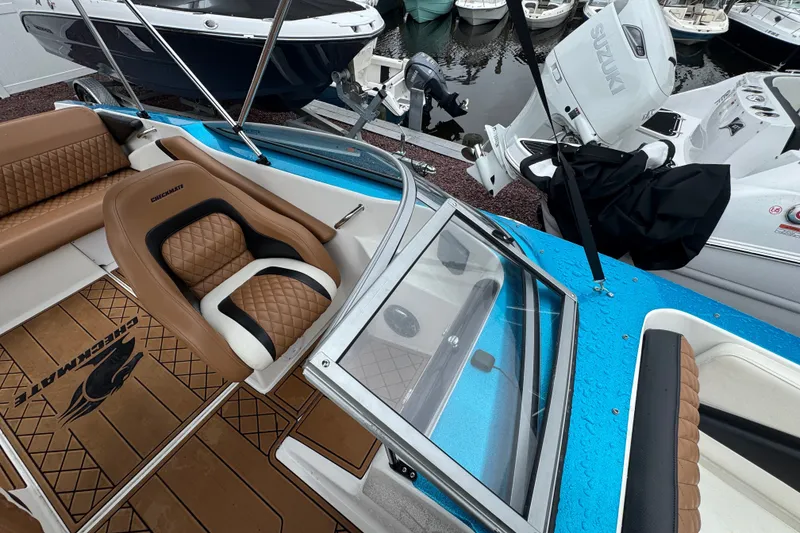 Slide: The Image of 2021 Checkmate Pulsare 2400 BRX boat interior with brown seating and blue accents. - 28