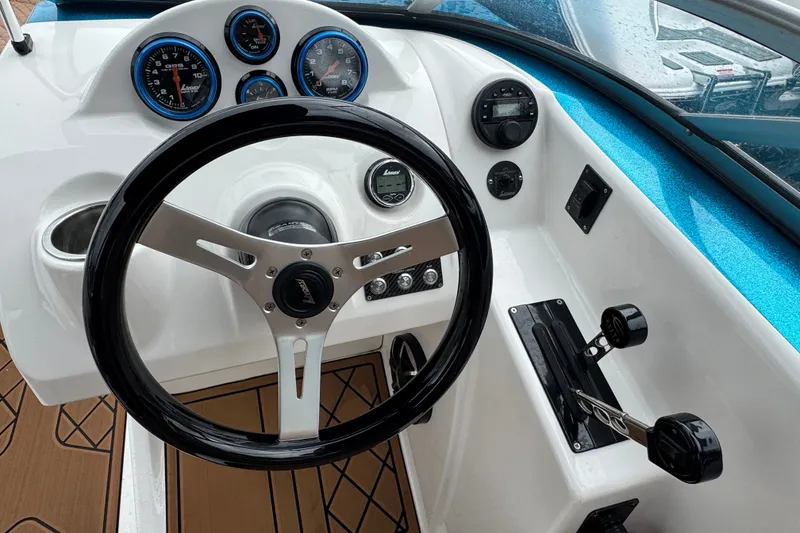 Slide: The Image of 2021 Checkmate Pulsare 2400 BRX boat dashboard with steering wheel and gauges. - 15
