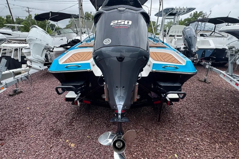 Slide: The Image of 2021 Checkmate Pulsare 2400 BRX boat with powerful outboard motor, displayed on gravel. - 3