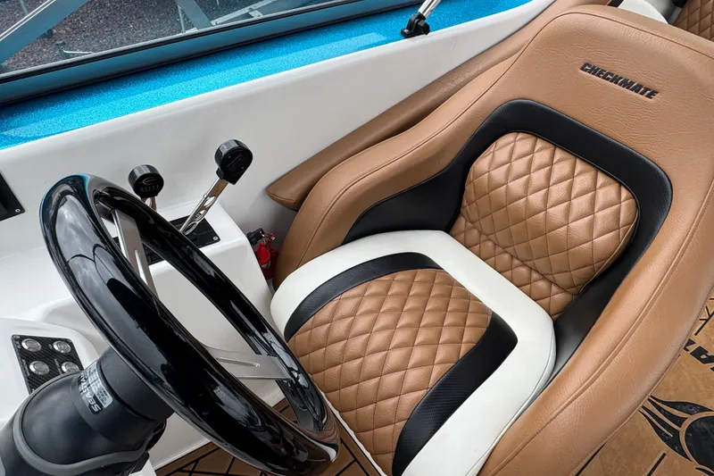 Slide: The Image of 2021 Checkmate Pulsare 2400 BRX cockpit with quilted leather seat and steering wheel. - 12
