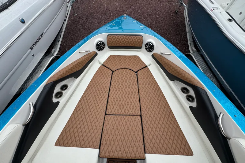 Slide: The Image of 2021 Checkmate Pulsare 2400 BRX boat interior with diamond-stitched brown seating and cup holders. - 25