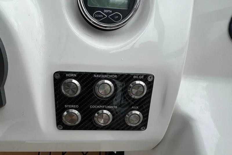 Slide: The Image of Control panel of 2021 Checkmate Pulsare 2400 BRX boat with labeled buttons. - 18