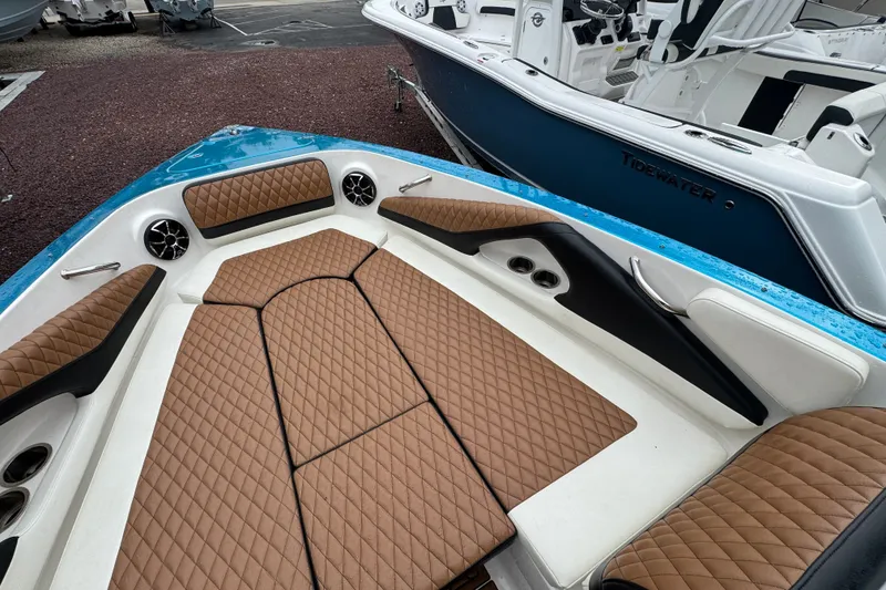 Slide: The Image of 2021 Checkmate Pulsare 2400 BRX boat interior with brown diamond-stitched seating and blue accents. - 24
