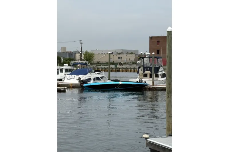 Slide: The Image of 2021 Checkmate Pulsare 2400 BRX boat docked at a marina, surrounded by other vessels. - 31