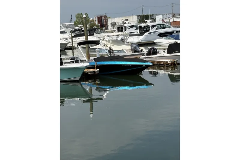 Slide: The Image of 2021 Checkmate Pulsare 2400 BRX boat docked in a marina with other vessels. - 4