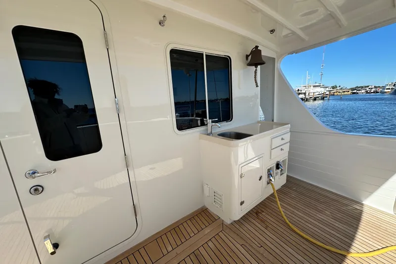 Slide: The Image of Kadey-Krogen 58EB 2017 yacht deck with sink, bell, and marina view. - 50
