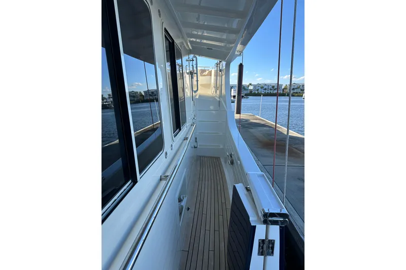 Slide: The Image of 2017 Kadey-Krogen 58EB yacht side deck with teak flooring and waterfront view. - 56