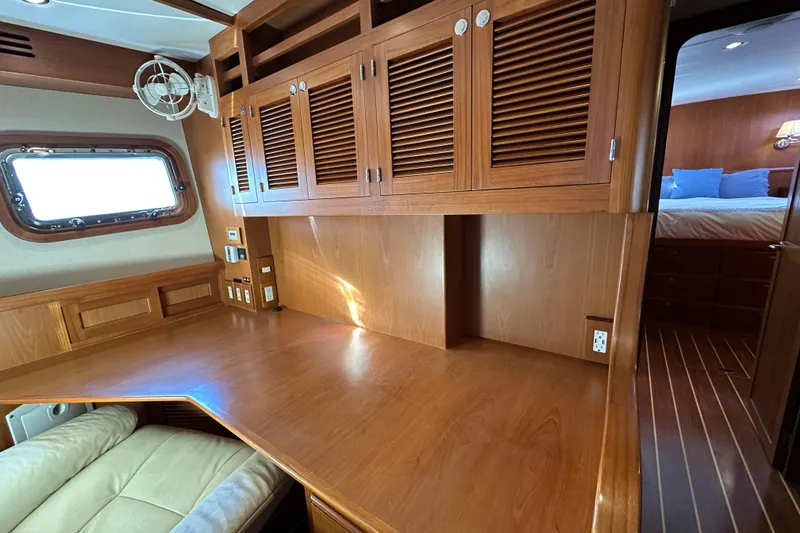 Slide: The Image of Luxurious 2017 Kadey-Krogen 58EB yacht interior with wooden cabinetry and cozy seating area. - 32