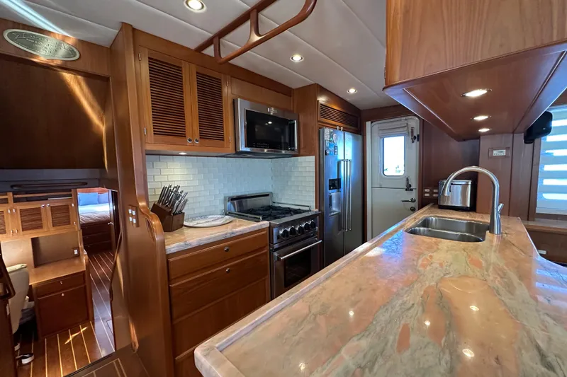 Slide: The Image of Luxurious 2017 Kadey-Krogen 58EB yacht kitchen with modern appliances and elegant wood finishes. - 17