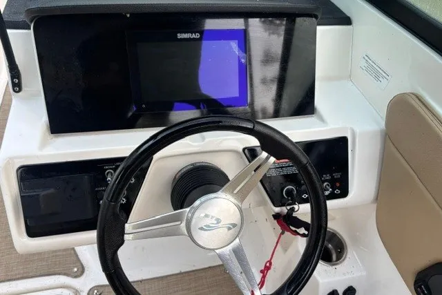 Slide: The Image of 2023 Sea Ray SPX 210 dashboard with steering wheel and Simrad display. - 8