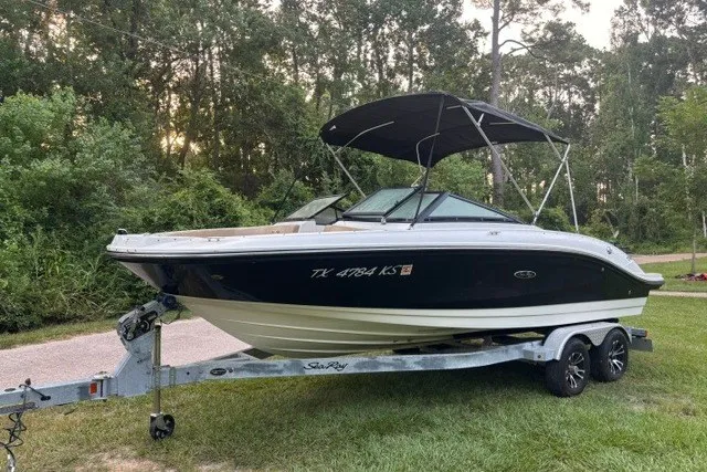 Slide: The Image of 2023 Sea Ray SPX 210 boat on trailer, parked on grass with forest background. - 5