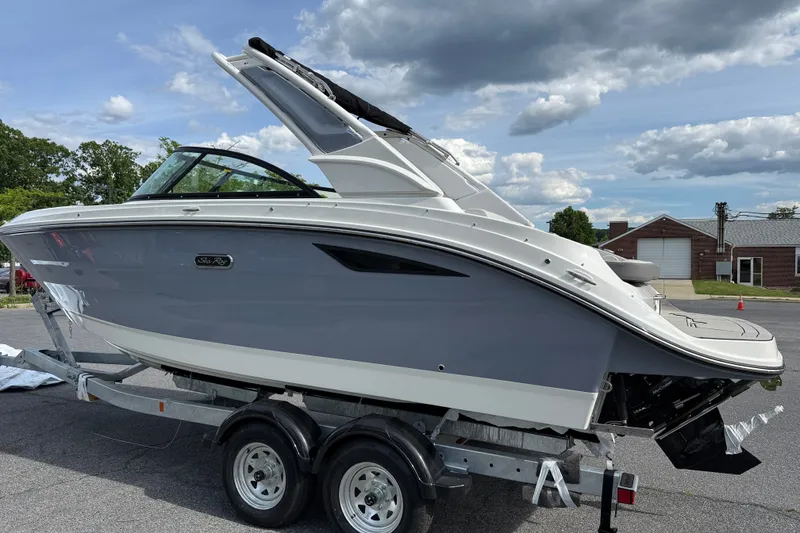 Slide: The Image of 2026 Sea Ray SDX 230 boat on trailer, parked outdoors under cloudy sky. - 3