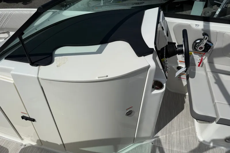 Slide: The Image of 2026 Sea Ray SDX 230 boat helm with steering wheel and seating area. - 7