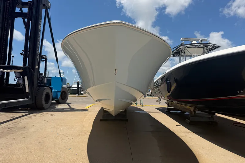 Slide: The Image of 2019 Invincible 36 Open Fisherman boat on dock, with forklift and another boat nearby. - 3