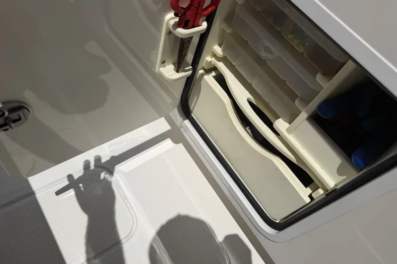 Slide: The Image of Storage compartment on a 2019 Invincible 36 Open Fisherman boat, featuring organized tackle boxes. - 31