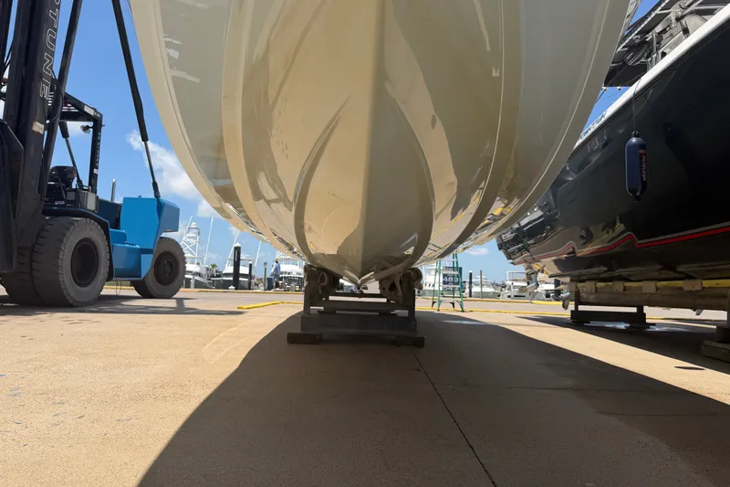 Slide: The Image of 2019 Invincible 36 Open Fisherman boat hull on dry dock, with forklift nearby. - 6