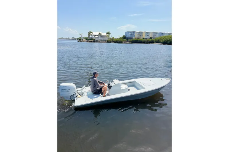 Slide: The Image of Man operating a 2024 Homeade 15 boat with Suzuki motor on a calm waterway. - 9