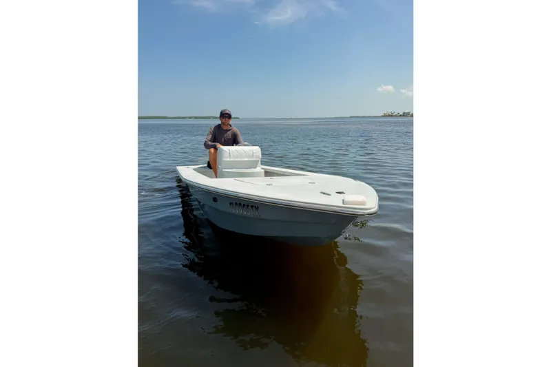 Slide: The Image of A person on a 2024 Homeade 15 boat in calm waters under a clear sky. - 10