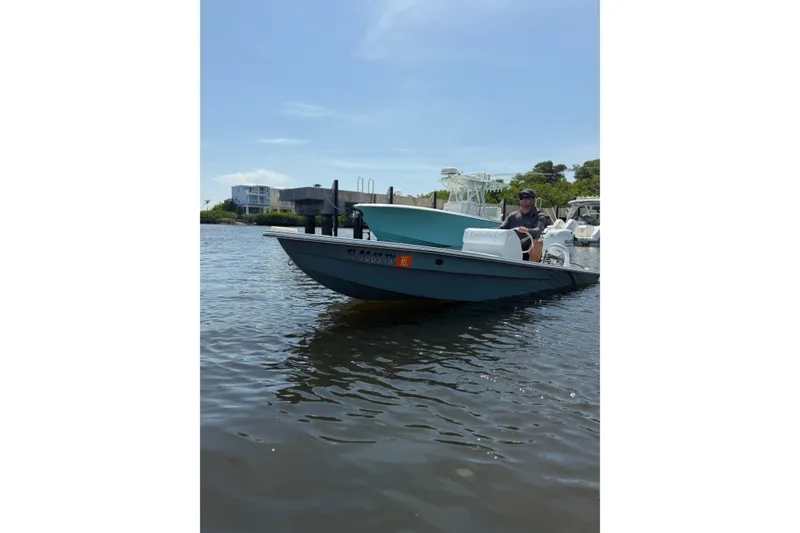 Slide: The Image of Small blue boat on water, person steering, clear sky, 2024 Homeade model 15. - 12