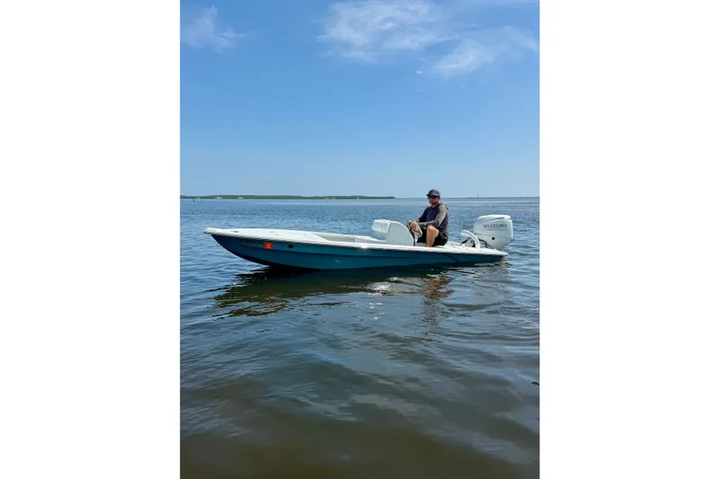Slide: The Image of Man on a 2024 Homeade 15 boat with Suzuki motor on calm water. - 1