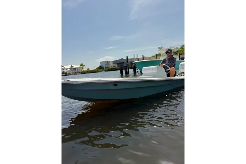 Slide: The Image of Man steering a 2024 Homeade 15 boat on a sunny day. - 13