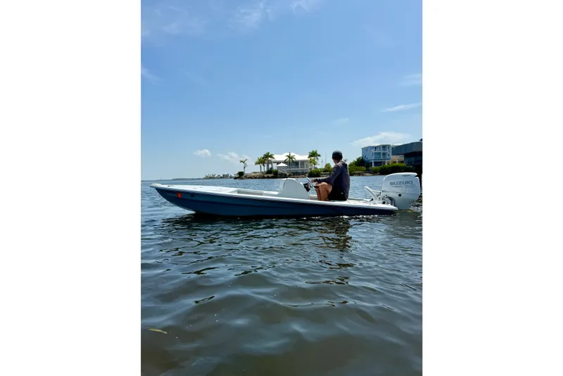 Slide: The Image of Man on a 2024 Homeade 15 boat with Suzuki motor, near waterfront homes. - 11