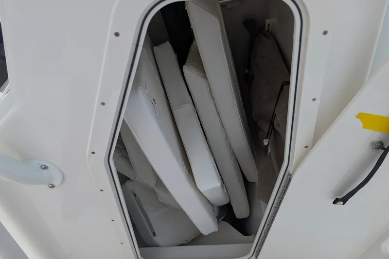 Slide: The Image of A storage compartment with white cushions and pads inside a boat. - 16
