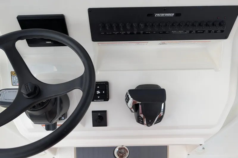 Slide: The Image of The image shows the helm of a Pathfinder 2600 Hybrid boat with a steering wheel and controls. - 14