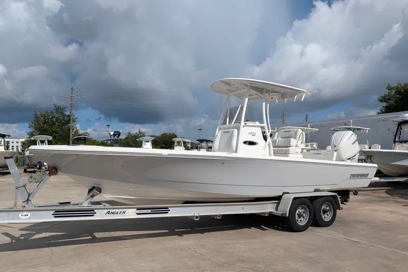 The Image of 2027 Pathfinder 2600 Hybrid on a trailer, featuring a T-top and outboard motor. - 0