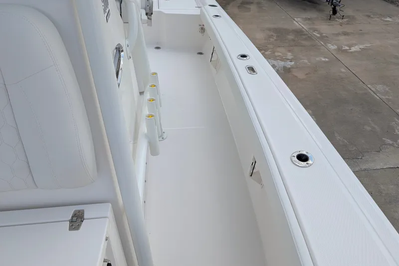 Slide: The Image of The image shows the white deck of a Pathfinder 2600 Hybrid boat with multiple fishing rod holders. - 33