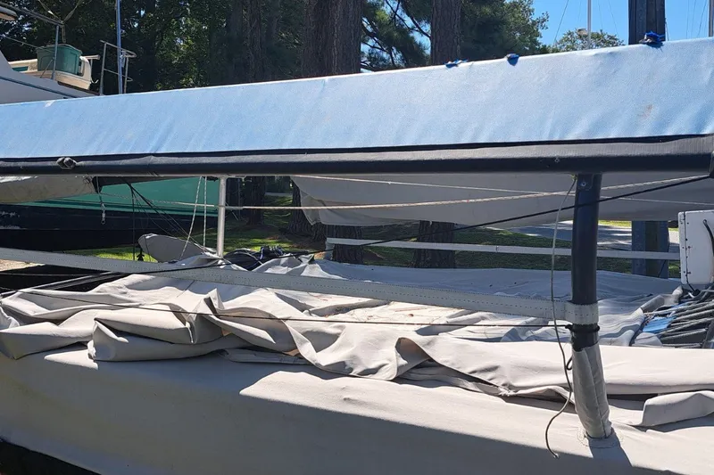 Slide: The Image of 1989 Hobie Cat 21 sailboat with folded sails, docked outdoors. - 3