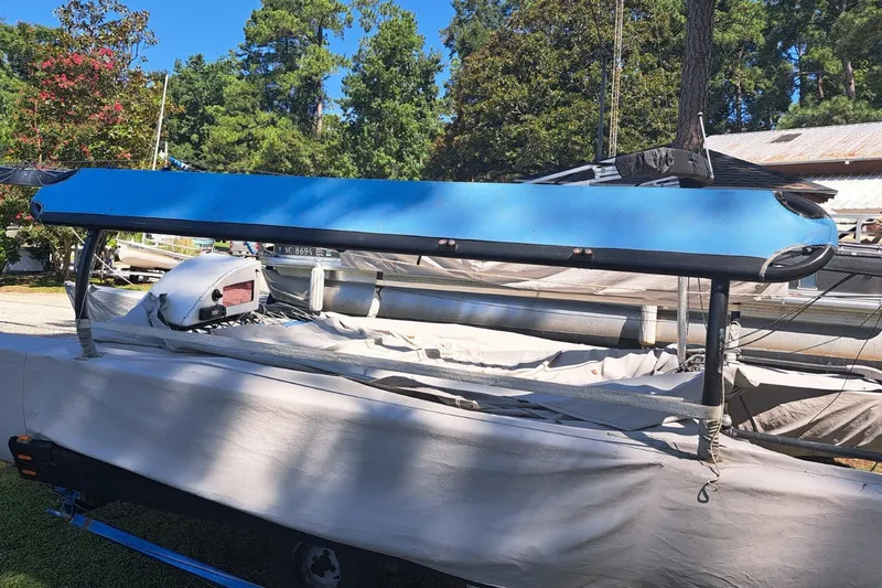 Slide: The Image of 1989 Hobie Cat 21 sailboat with blue hull, parked outdoors on a sunny day. - 2