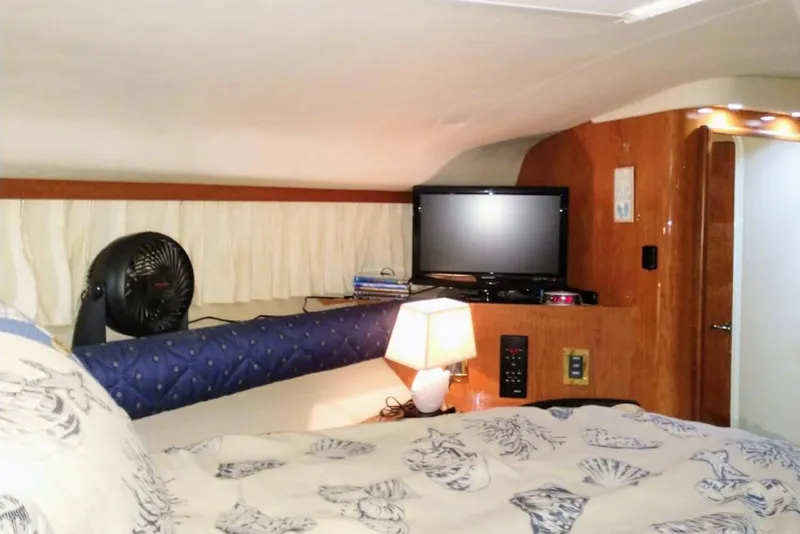Slide: The Image of Interior cabin of 1999 Sea Ray Sundancer 400 with bed, TV, and lamp. - 8
