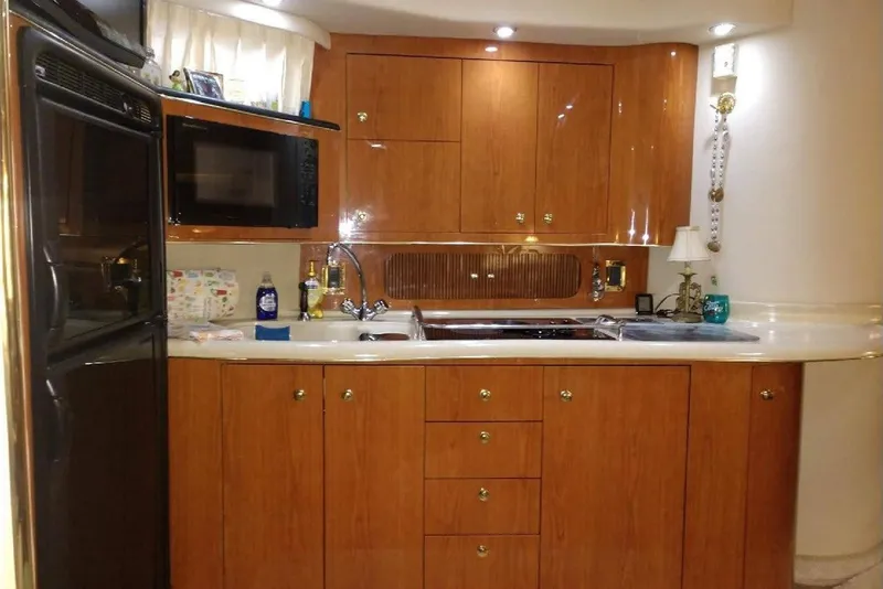 Slide: The Image of Interior of 1999 Sea Ray Sundancer 400 yacht kitchen with wooden cabinets and modern appliances. - 6
