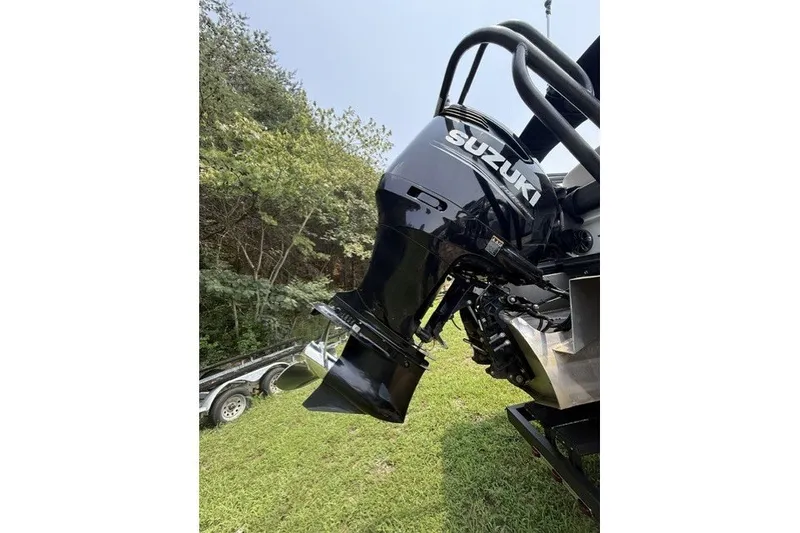 Slide: The Image of Suzuki outboard motor on 2018 Crest Caribbean 250 SLS boat, parked on grass. - 5