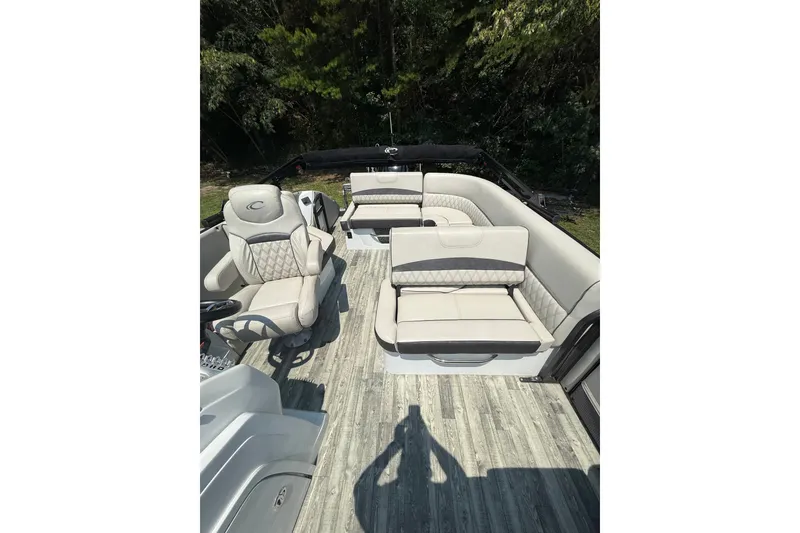 Slide: The Image of 2018 Crest Caribbean 250 SLS boat interior with plush seating and wood-style flooring. - 11