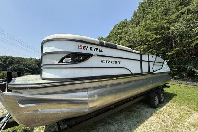 Slide: The Image of 2018 Crest Caribbean 250 SLS pontoon boat on trailer, parked on grass. - 2
