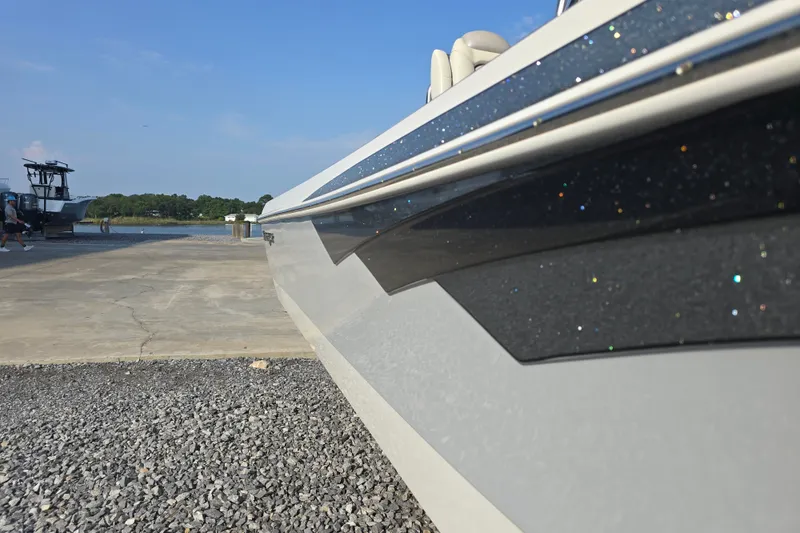 Slide: The Image of 2019 Ranger 2360 Bay Ranger boat docked on gravel near water. - 8