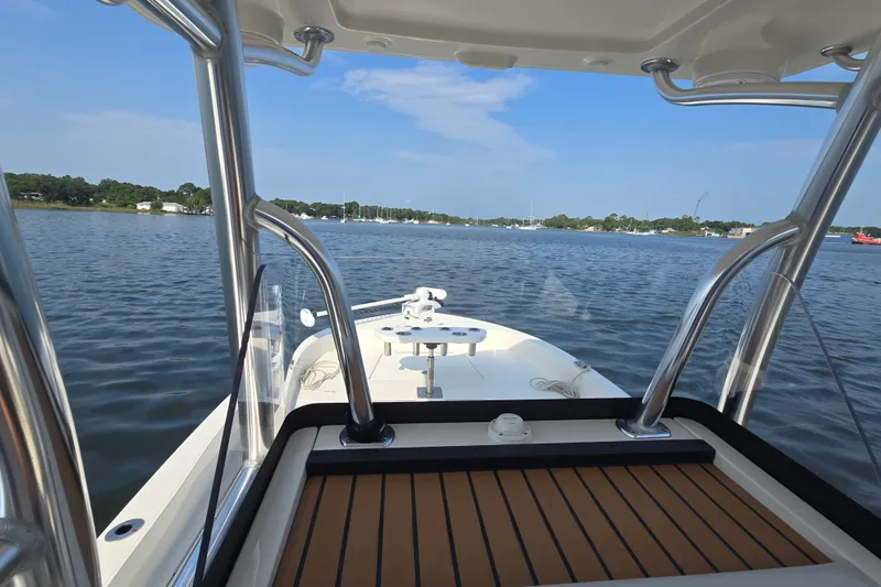 Slide: The Image of 2019 Ranger 2360 Bay Ranger boat on calm water, featuring sleek design and sturdy structure. - 14
